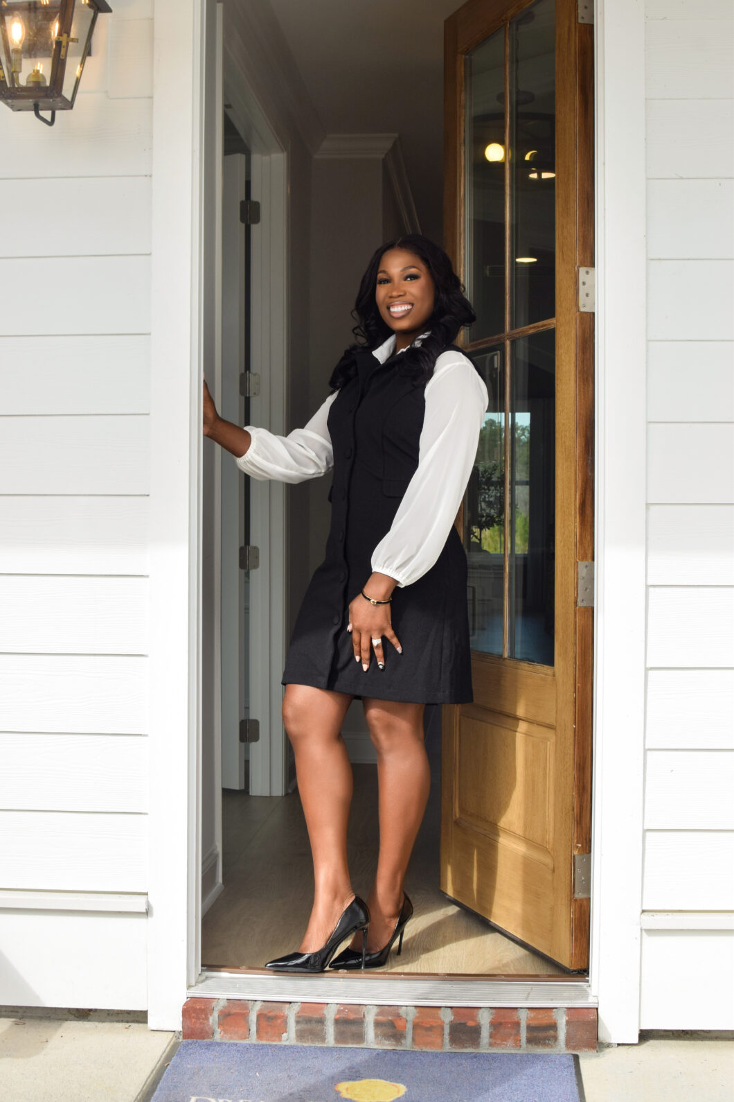 Whitney Middleton holding open the front door of a home